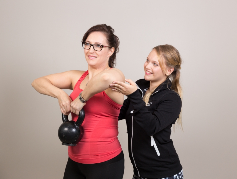 Personal Trainer opastaa asiakasta oikeaan tapaan tehdä liikunnallista harjoitusta